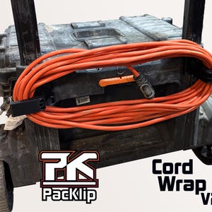 Puede incluir: Un cable de extensión naranja enrollado alrededor de un carro de herramientas negro. El cable está asegurado con abrazaderas para cables Packlip negras. El logotipo de Packlip y "Cord Wrap V2" son visibles. Una herramienta eléctrica roja y negra está a la izquierda.