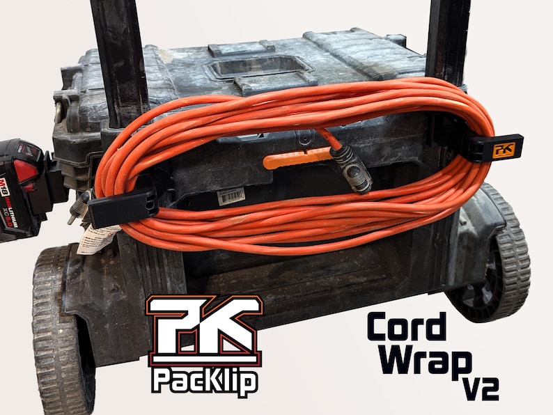 May include: An orange extension cord wrapped around a black utility cart. The cord is secured with black Packlip cord wraps. The Packlip logo and "Cord Wrap V2" are visible. A red and black power tool is on the left.