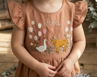 May include: A rust-colored dress with flutter sleeves featuring embroidered details including the name Ava, white daisies, three balloons, a wooden fence, a white goose, and a brown cow wearing a colorful party hat on the front bodice.