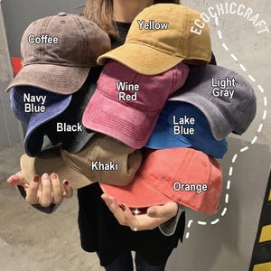 May include: A collection of baseball caps in various colors, including coffee, yellow, wine red, navy blue, black, khaki, lake blue, orange, and light gray. Each cap has a curved brim and adjustable strap. The text "ECOCHIC CRAFT" is visible.