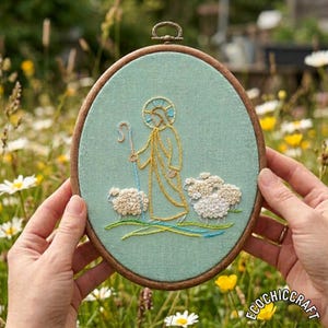 以下が含まれることがあります： 楕円形の刺繍枠。牧歌的なシーンが描かれており、金、白、青の糸で刺繍された、光輪と杖を持った羊飼いと2匹の羊が、淡いティール色の生地に描かれています。木製のフレームが付いています。
