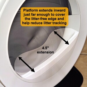 Op de afbeelding: Een witte plastic opzetstuk voor de ingang van een kattenbak met een verlenging van 11,43 cm. De tekst op de afbeelding luidt: Platform extends inward just far enough to cover the litter-free edge and help reduce litter tracking, en 4.5-inch extension.