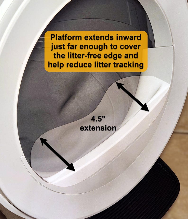 Op de afbeelding: Een witte plastic opzetstuk voor de ingang van een kattenbak met een verlenging van 11,43 cm. De tekst op de afbeelding luidt: Platform extends inward just far enough to cover the litter-free edge and help reduce litter tracking, en 4.5-inch extension.