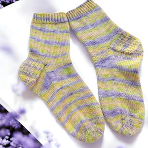 May include: A pair of striped socks in shades of purple, yellow, and green. The socks are made of a soft, knitted fabric.