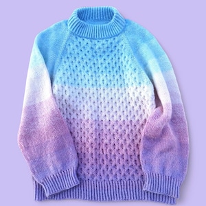 May include: A soft, knitted sweater with a gradient of pink, white, and blue colors. The sweater has a high neck and long sleeves.