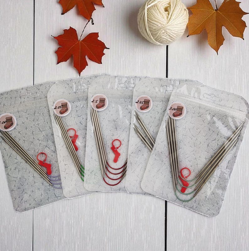 Puede incluir: Cinco juegos de agujas de tejer en bolsas de pl&aacute;stico transparente, cada uno con una aguja circular y marcadores de punto. Las bolsas tienen pegatinas con un gr&aacute;fico de calcet&iacute;n y el tama&ntilde;o de la aguja. Hojas de oto&ntilde;o y una madeja de lana en el fondo.