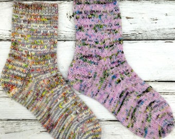 May include: Two pairs of colourful knitted socks. One pair is grey with multi-coloured flecks and the other pair is pink with multi-coloured flecks.