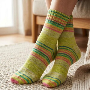 Peut inclure: Une paire de chaussettes ray&eacute;es aux tons de vert, rose, bleu et jaune. Les chaussettes ont un bord-c&ocirc;te et un bout rose. Les chaussettes sont faites d'une mati&egrave;re tricot&eacute;e douce.