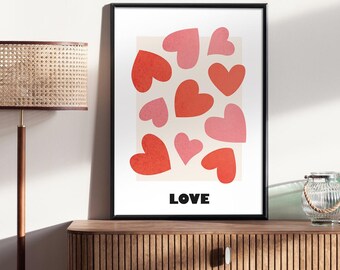 May include: A framed print with a white background and a pattern of red and pink hearts. The word "LOVE" is printed in black at the bottom of the print.