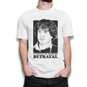 Puede incluir: Camiseta blanca con una ilustraci&oacute;n en blanco y negro de la cara de un hombre y el texto "EVERYDAY IS ANOTHER BETRAYAL".