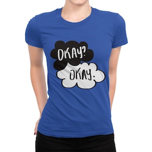 May include: A royal blue t-shirt with a black and white graphic of two speech bubbles. The top speech bubble says "OKAY?" and the bottom speech bubble says "OKAY."