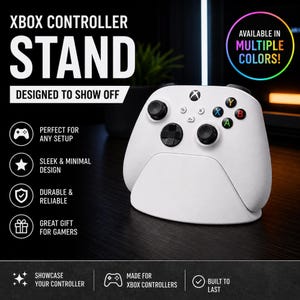 May include: A white gaming controller stand holding a white Xbox controller. The image includes text: XBOX CONTROLLER STAND, DESIGNED TO SHOW OFF, AVAILABLE IN MULTIPLE COLOURS, PERFECT FOR ANY SETUP, SLEEK & MINIMAL DESIGN, DURABLE & RELIABLE, GREAT GIFT FOR GAMERS.