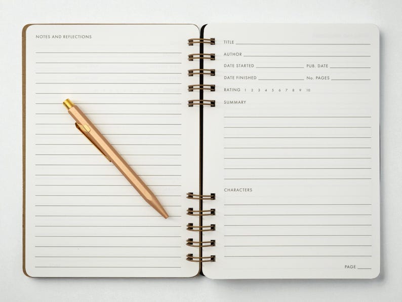 Two-page interior spread of the reading journal showing the lined “Notes and Reflections” page on the left and the structured book review layout on the right. A rose gold tone metal pen rests diagonally across the notes page. Photographed on a white background.