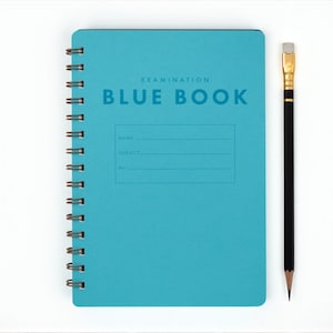 May include: A teal spiral-bound "BLUE BOOK" examination notebook with lines for name, subject, and number, next to a black pencil with a gold eraser. The notebook has the text "EXAMINATION BLUE BOOK".