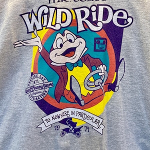 May include: A gray sweatshirt featuring a colorful graphic of Mr. Toad from Disney's Wild Ride. The design includes the ride's name, a cartoon toad driving a car, and the text "To Nowhere in Particular". The sweatshirt also has the text "Opening Day 1971".
