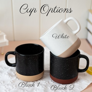 May include: Three ceramic mugs labeled Cup Options. One white mug with speckles and a tan base is labeled White. Two black mugs with white speckles are labeled Black 1 and Black 2; Black 1 has a tan base, and Black 2 has a dark reddish-brown base.