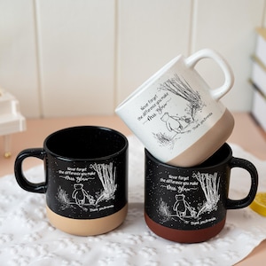 May include: Three ceramic mugs featuring a white line art illustration of a bear walking in a forest. Each mug displays the text 'Never forget the difference you make', 'Mrs. Glow', and 'Thank you Brenda'. Two mugs are black, one is white.