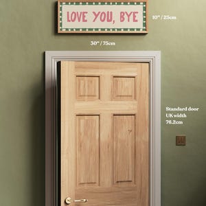 May include: A green wall with a wooden door and a framed sign that reads "LOVE YOU, BYE". The sign is 30 inches wide and 10 inches tall. The door is a standard UK door width of 76.2 cm.