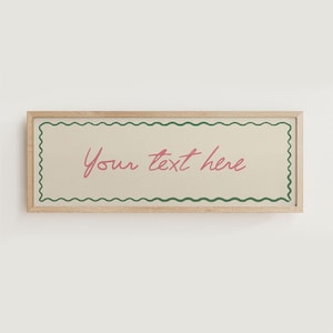 Puede incluir: Un letrero rectangular con marco de madera con el texto "Your text here" en escritura cursiva rosa. El letrero tiene un fondo beige con un borde ondulado verde y un marco de madera marrón claro.