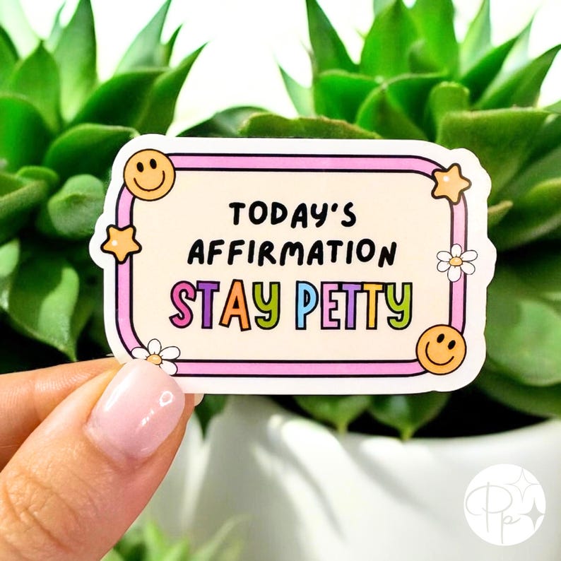 May include: A sticker with the text "TODAY'S AFFIRMATION STAY PETTY" in black and colorful letters. The sticker has a light beige background with a pink border, smiley faces, stars, and flowers.