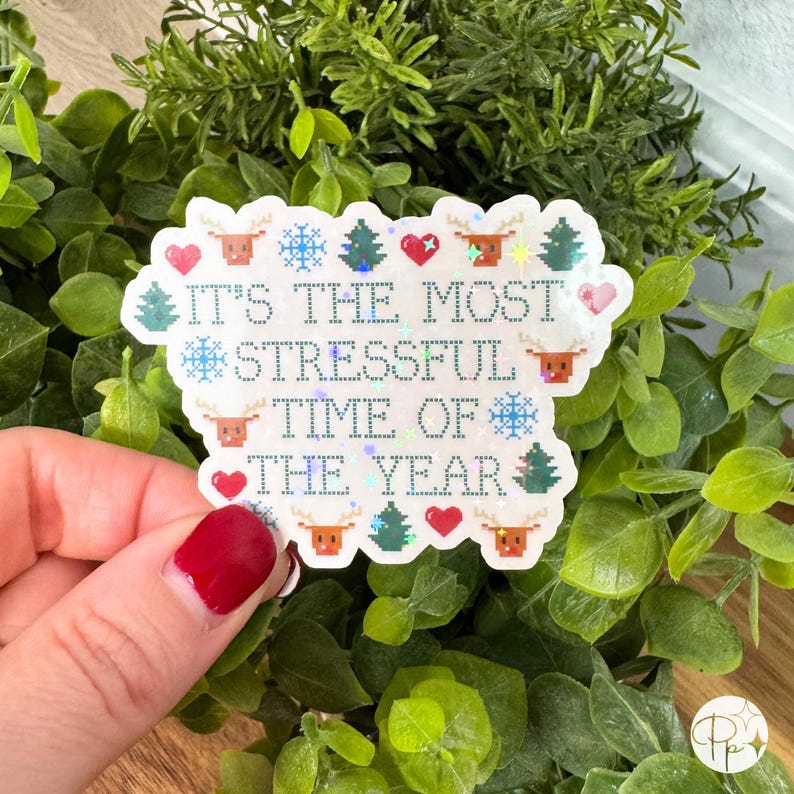 A holographic version of the “It’s the Most Stressful Time of the Year” holiday sticker with a shimmering rainbow finish. The cross-stitch inspired design features tiny pixel reindeer, trees, and snowflakes that sparkle as the light moves. Ideal for holiday gifting, stocking stuffers, or adding humor to your laptop, tumbler, or journal. Waterproof and handmade, available in a holographic finish.