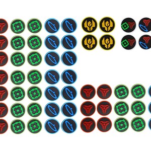 May include: A collection of circular game tokens featuring various graphic icons in red, green, blue, and yellow. The set includes multiple rows of tokens with distinct symbols, including triangular, square, and orbital designs on black backgrounds.