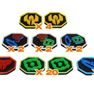 May include: A collection of octagonal game tokens featuring black centers with colored borders and raised symbols in red, green, blue, and yellow. The set includes various quantities labeled with orange X4, X2, and X20 text markers throughout.