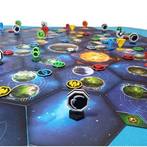 May include: A board game featuring a hexagonal space map with printed planet illustrations and various colored plastic tokens. The game board consists of dark blue space tiles with grid lines, while upright markers in red, yellow, green, and black stand on top.