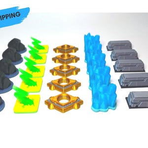 Puede incluir: Una colección de piezas de juego en miniatura de varias formas y colores. Incluye formaciones rocosas de color gris oscuro, rayos amarillos, formas geométricas doradas, cristales de hielo azules y estructuras rectangulares grises.