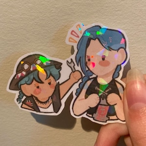 May include: Two cartoon characters with blue and green hair wearing black and white clothing. The character on the left is holding a wrench and the character on the right is holding a wrench and a small can.