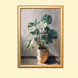 May include: A framed painting of a potted Monstera plant. The plant has large, green, and white variegated leaves. The pot is a light brown color. The frame is gold. The background is a light gray color.