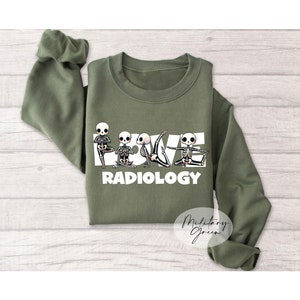 May include: A green sweatshirt with the words "LOVE RADIOLOGY" printed on the front. The word "LOVE" is spelled out using skeletons in yoga poses.