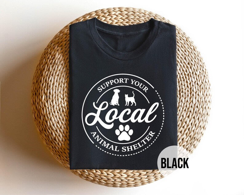 May include: Black t-shirt with a white circle graphic that says "Support Your Local Animal Shelter" with a paw print in the center and silhouettes of a dog and cat.