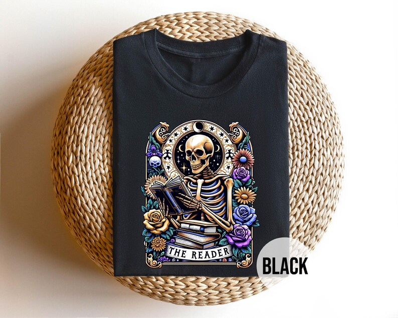 May include: Black t-shirt with a graphic of a skeleton reading a book surrounded by flowers. The text "The Reader" is below the skeleton.