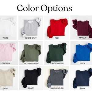 May include: A color chart showing 12 different sweatshirt colors. The colors are: white, sport gray, red, maroon, light pink, military green, forest green, royal, sand, black, dark heather, and navy.