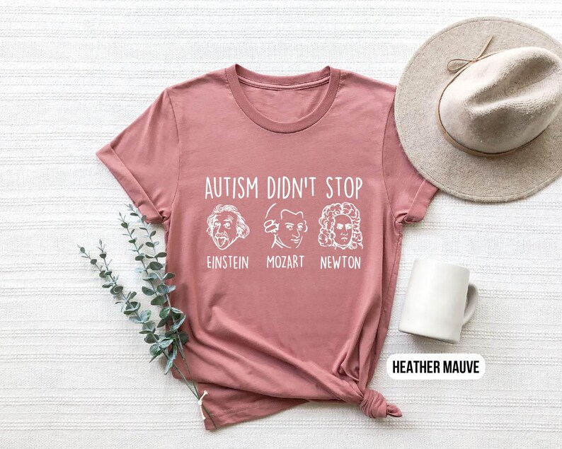 Pu&ograve; includere: T-shirt color malva heather con il testo "L'autismo non si &egrave; fermato" e immagini di Einstein, Mozart e Newton.