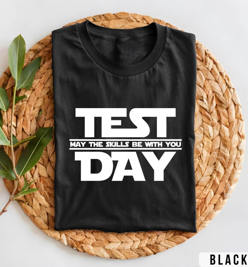 K&ouml;nnte beinhalten: Schwarzes T-Shirt mit wei&szlig;em Text, der "TEST MAY THE SKILLS BE WITH YOU DAY" lautet.