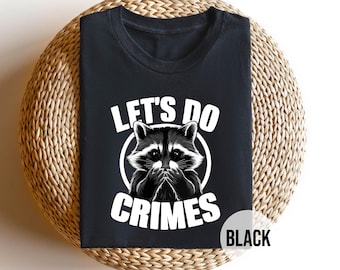 May include: Black t-shirt with a white graphic of a raccoon with the text "Let's Do Crimes".