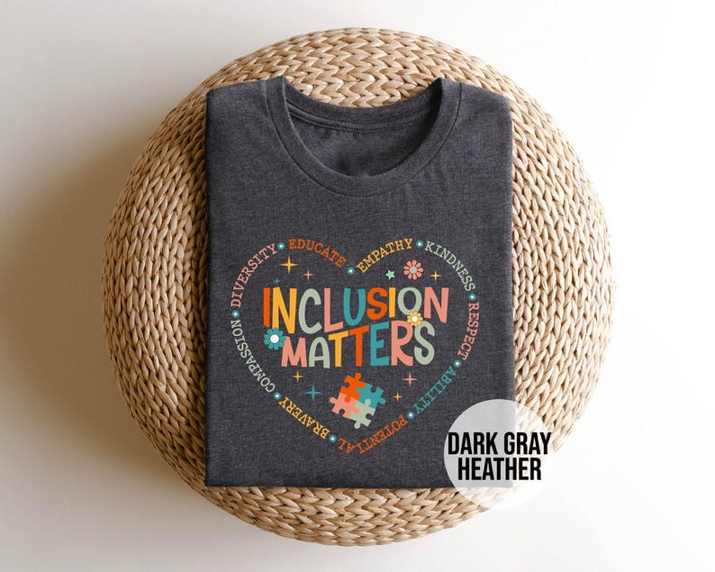 May include: Dark gray heather t-shirt with a colorful graphic of a heart with the words "Inclusion Matters" surrounded by words like "diversity", "empathy", "kindness", and "respect".