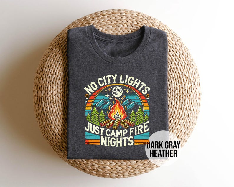 K&ouml;nnte beinhalten: Dunkelgraues T-Shirt aus Heather-Material mit einem Retro-Grafikdesign, das ein Lagerfeuer, Berge und den Text "No City Lights Just Camp Fire Nights" zeigt.