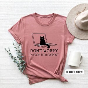 May include: Heather mauve t-shirt with a black cat sitting on a laptop. The text on the shirt reads "Don't worry I'm from tech support."
