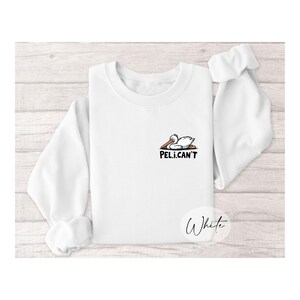 May include: White sweatshirt with a cartoon pelican graphic and the text "PEL.I.CAN'T".