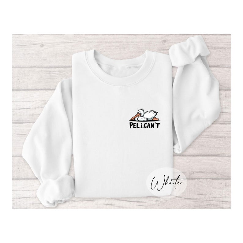 May include: White sweatshirt with a cartoon pelican graphic and the text "PEL.I.CAN'T".