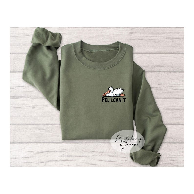 May include: A green sweatshirt with a white pelican graphic and the text "Peli.Can't".
