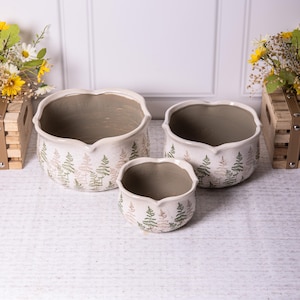 May include: Three white ceramic planters with a fern pattern. The planters are different sizes and have a scalloped edge.