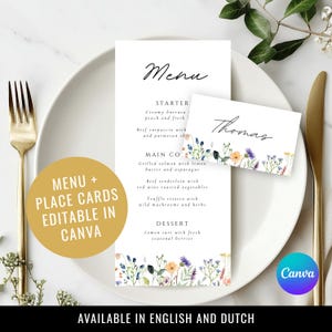 Op de afbeelding: Een wit papieren menu en een rechthoekig naamkaartje met de naam Thomas, beide voorzien van aquarelillustraties van wilde bloemen aan de onderkant. Het menu toont gerechten in zwarte tekst. Een gouden cirkel bevat de tekst MENU + PLACE CARDS EDITABLE IN CANVA.