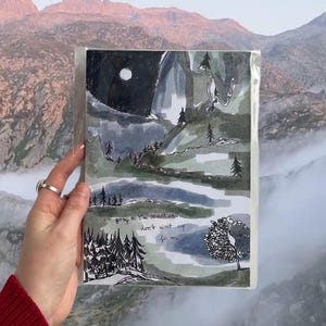 Peut inclure: Une peinture à l'aquarelle d'un paysage de montagne avec une lune dans le ciel. Le texte "Je vais à la montagne, n'attendez pas mon retour" est écrit à l'encre noire en bas de la peinture.