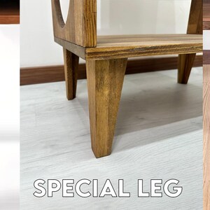 Puede incluir: Tres tipos diferentes de patas para muebles: una pata de hierro negra, una pata de madera marr&oacute;n y una pata especial de madera con una forma &uacute;nica.