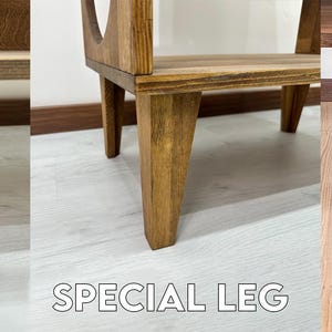 May include: Three different types of legs for a wooden shelf unit. The first leg is made of black metal and is shaped like a hairpin. The second leg is made of wood and is shaped like a tapered rectangle. The third leg is made of wood and is shaped like a tapered cylinder.