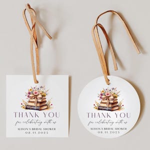May include: Two white gift tags with leather string. One is square, the other round. Both feature a watercolor illustration of books and flowers, with the text "THANK YOU for celebrating with us" and "ALISON'S BRIDAL SHOWER 08.11.2025".
